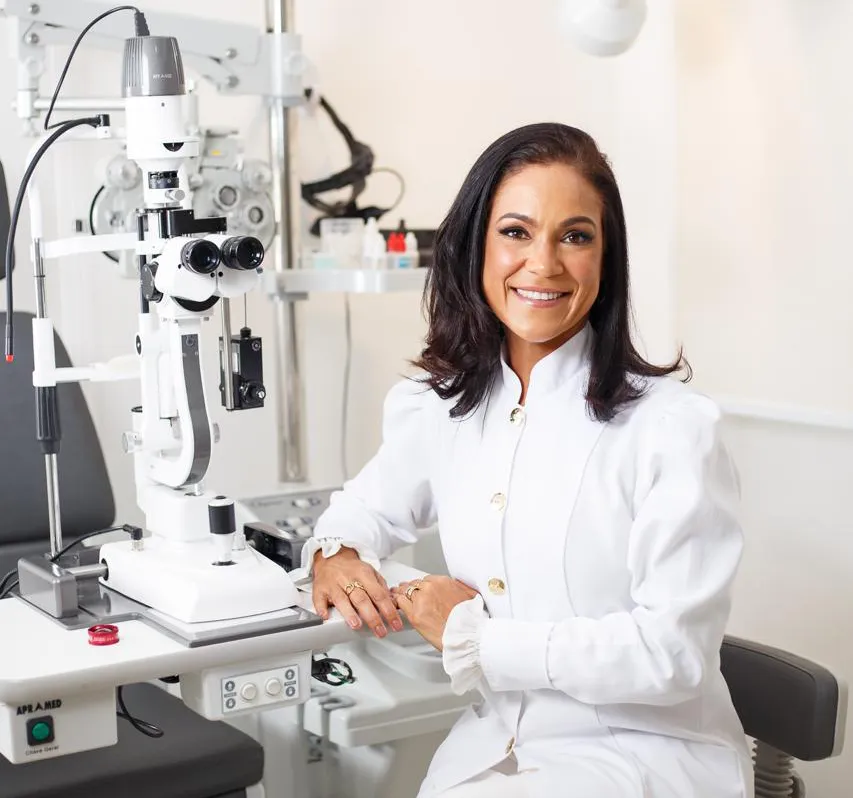 Dra. Vânia Correa junto a equipamento de exame oftalmológico